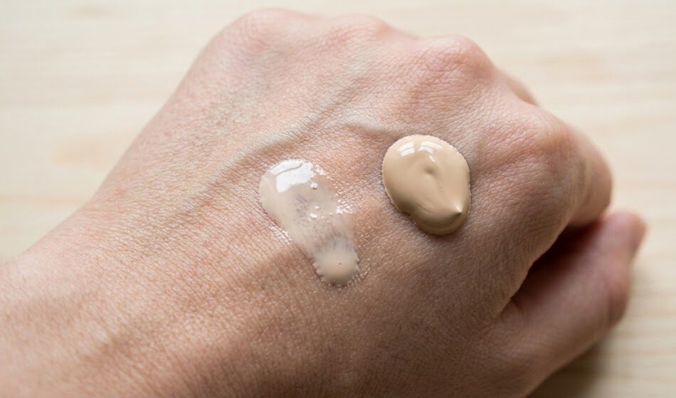 Tekstura produktu na dłoni. Widać kroplę kremu BB, która jest lekka i nawilżająca, obok gęstszej kropli klasycznego podkładu. Tekstura produktu na dłoni. Widać kroplę kremu BB, która jest lekka i nawilżająca, obok gęstszej kropli klasycznego podkładu.